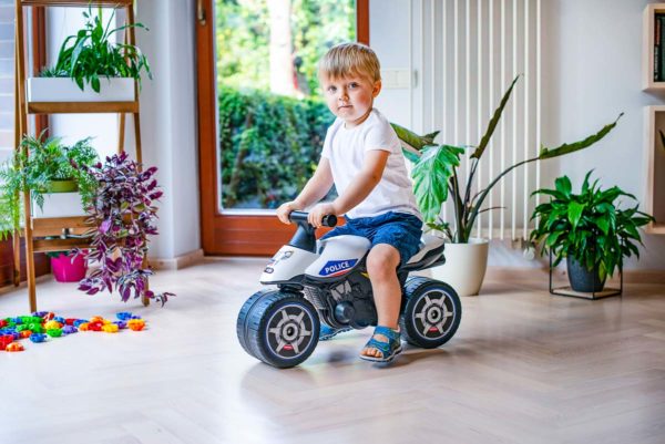 Niño jugando con Moto Correpasillos Policía Falk Toys 427 en aire libre
