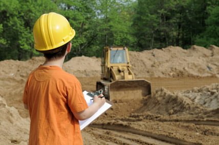 enfant regardant un engin de chantier