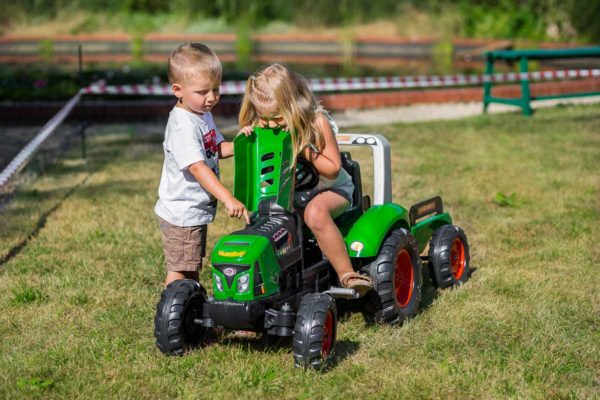 Niño jugando con Tractor de pedales Supercharger 2021AB en aire libre