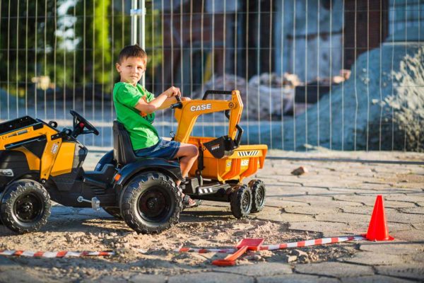 Kleiner spielender Junge mit Baggerlader Case Construction Falk Toys 997W im Freien