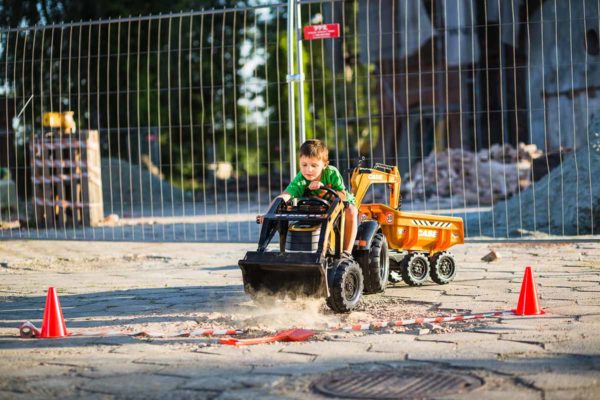 Kleiner spielender Junge mit Baggerlader Case Construction 997W im Freien