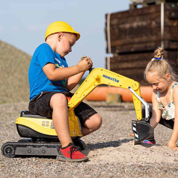 Garçon jouant Pelleteuse komatsu