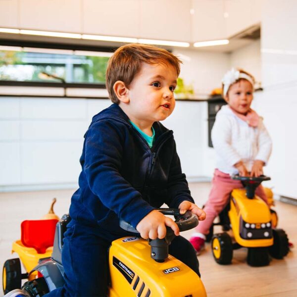 spielende Kind auf Träger JCB mit Anhänger