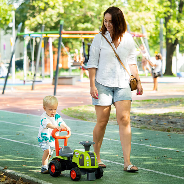 Kinder und Elternteil mit Träger Traktor Claas