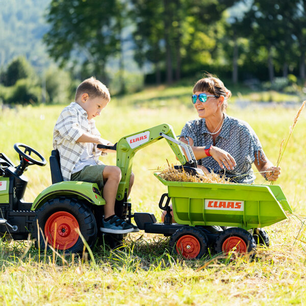 Enfant et parents avec Tractopelle Claas avec excavatrice et remorque basculante Maxi